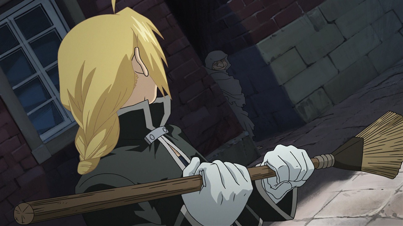 A screencap from Brotherhood. Edward Elric holds a broom, looking at Bido standing in the entrance of an alleyway.'